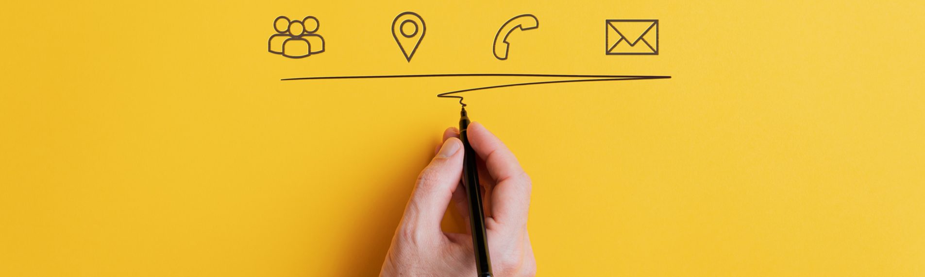 Male hand underlining hand drawn contact and communication icons on yellow background. With copy space.